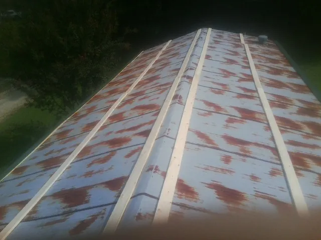 Rusted metal roof panels with new wood purlins before replacement — Storm Damage Roof Repair in Fort Dodge by Roofing Brothers